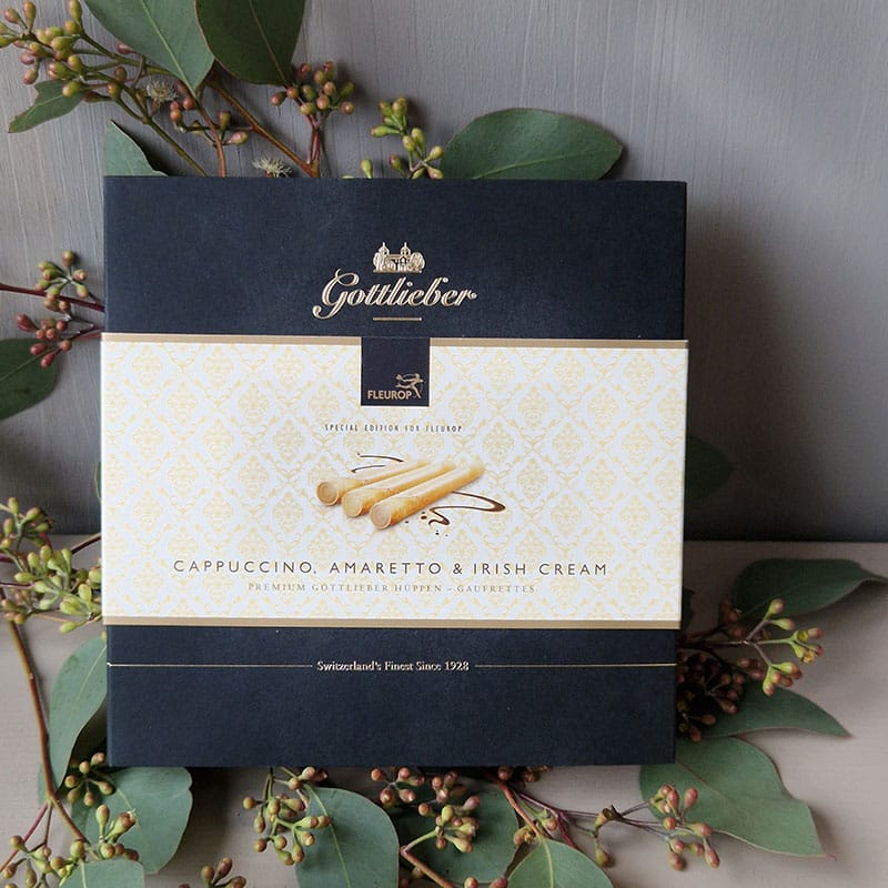 Gottlieber Waffelverpackung mit Cappuccino, Amaretto & Irish Cream Geschmacksrichtung, dekoriert mit grünen Blättern.